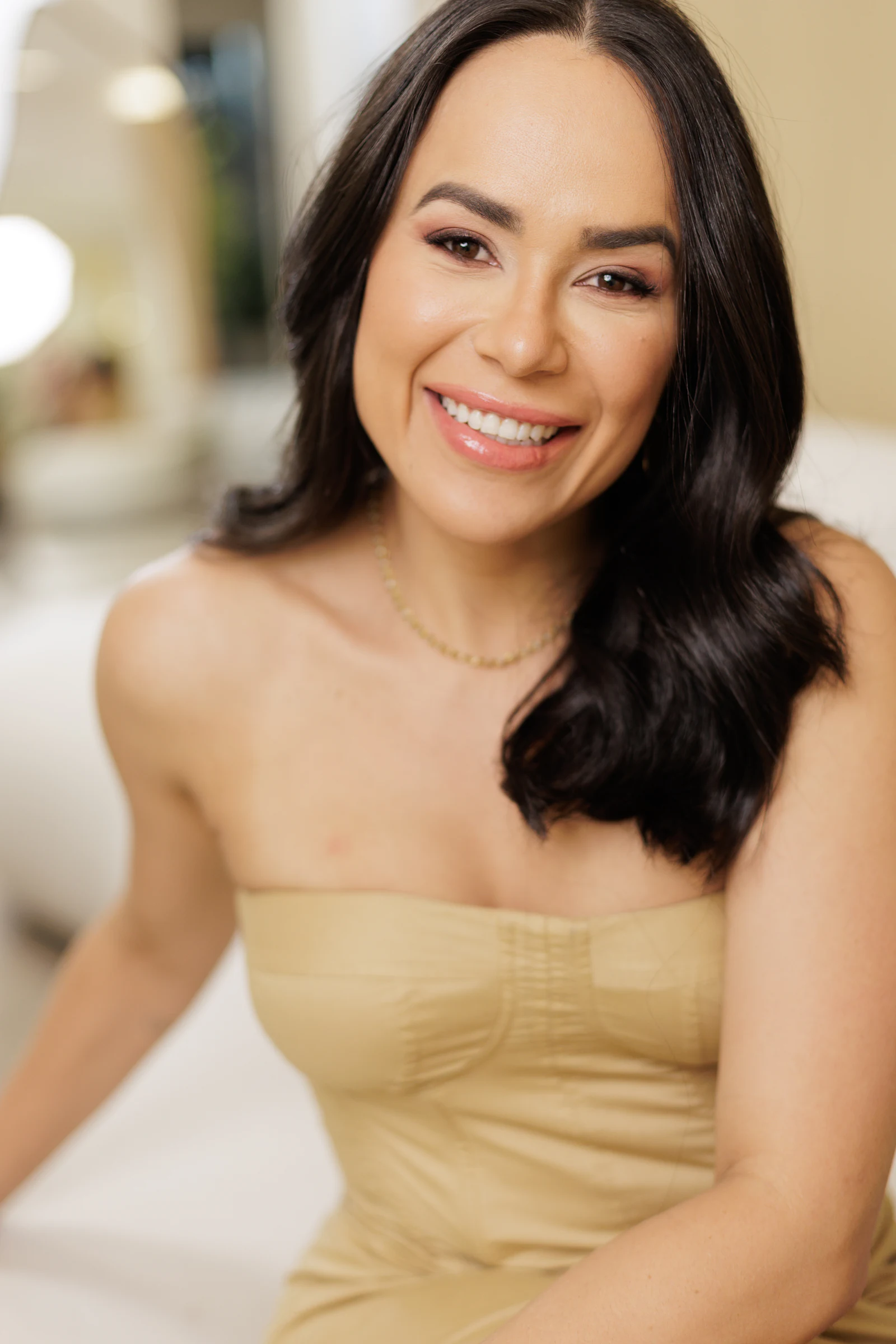 Retrato da Dra. Paula Fernandes sorrindo, de vestido bege, em ambiente claro